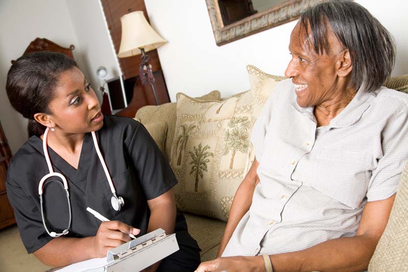 smiling elderly man being administered to by a friendly nurse