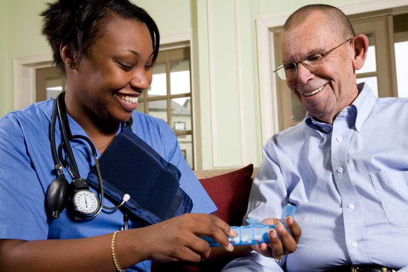 smiling friendly home nurse with elderly man